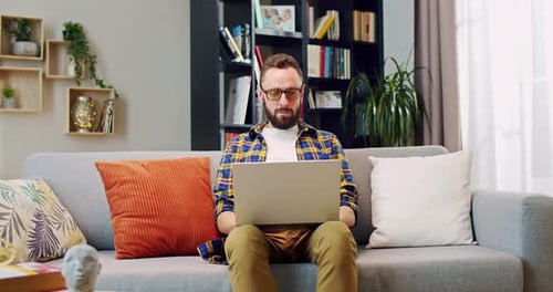 Bearded Man Working On Laptop At Home