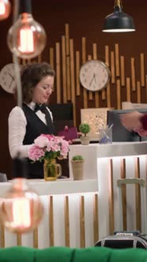 Hotel Receptionist Taking Payment from Hotel Guest