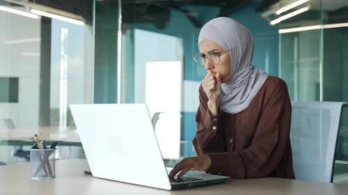 Woman Coughing at Computer in Office