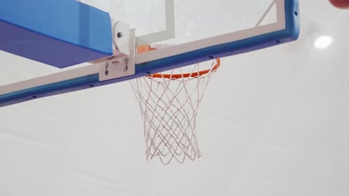 Basketball bouncing near the hoop in a close-up shot indoors