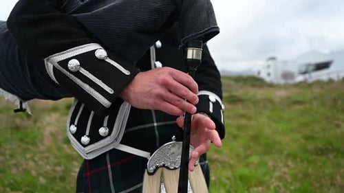 Nahaufnahme eines Dudelsackspielers, der in seinem traditionellen schottischen Kilt ein Lied spielt