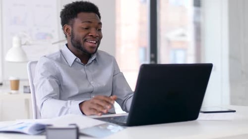 Man Video Conferencing in Office Using Laptop Computer