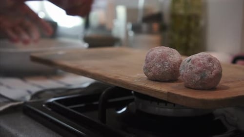 Raw Meatballs on Cutting Board in Bright Kitchen