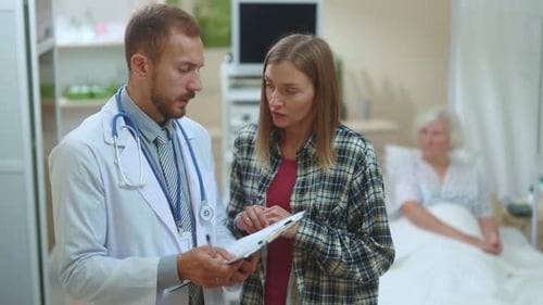 Doctor Consults with Woman in Hospital Room