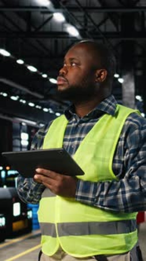 Vidéo verticale Le superviseur de l'usine vérifie l'équipement d'assemblage sur une tablette dans une usine de fabrication
