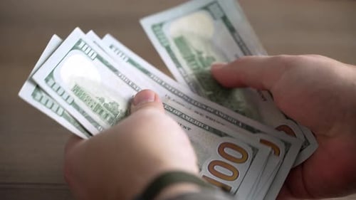 Close-up shots of men's hands counting dollars.