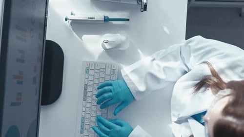 An Online Scientist Enters Data Into the Internet at His Workplace in His Laboratory A Doctor Works