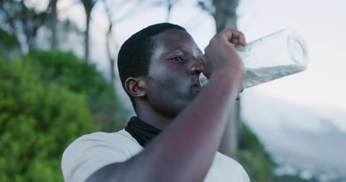 Runner, man and drinking water on mountain with exercise break, electrolytes
