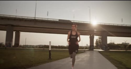 Woman Running in Park at Sunrise