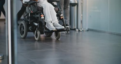 Aufnahme verschiedener Menschen auf Kniehöhe, die mit Gepäck im überfüllten Flughafenterminal spazieren