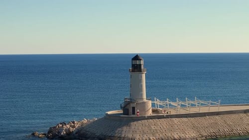 Wite bright lighthouse in a luxury tourist resort on the mediterranean sea with luxury marina yachts
