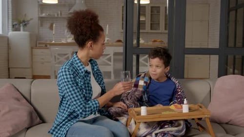Woman Gives Sick Child Medicine at Home