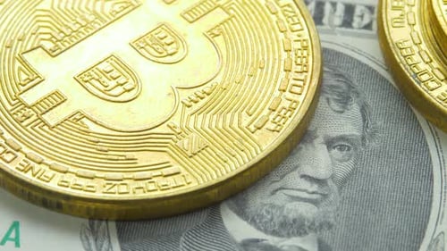 Golden Bitcoin on US Dollar Bill Close Up