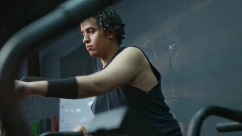Young Adult Working Out at Gym on Cardio Machine