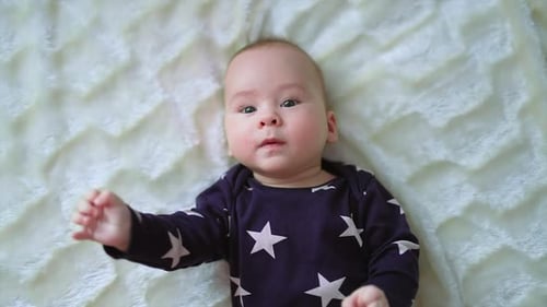 Baby Lying on a Blanket Waving Arms