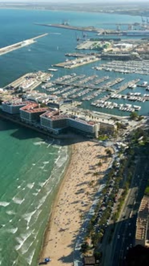 Aerial drone view of the Port of Alicante and the buildings in the city in daylight. Vertical