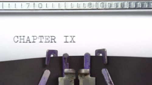 Chapter Nine phrase closeup being typing and centered on a sheet of paper on old vintage typewrite