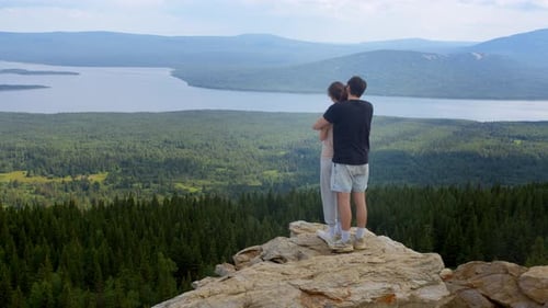Beautiful Young Couple is Enjoying a Wonderful View of the Natural Scenery at the Summit of the