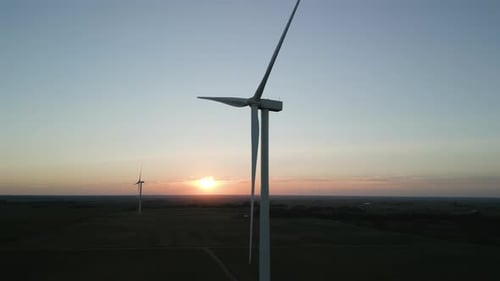 Aerial Drone Wide View of a Wind Park with Wind Turbines Standing in a Wheat Field at Sunset