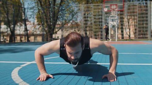 Adult Man Doing Push-Ups on Basketball Court