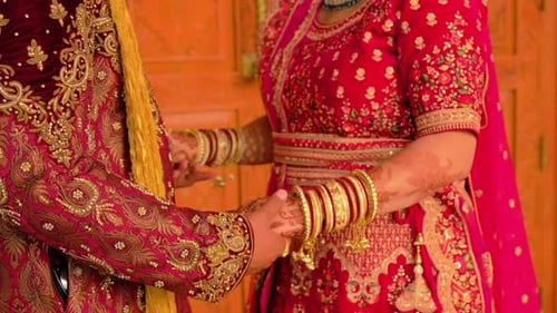 Paar steht zusammen in traditioneller roter indischer Kleidung Elemente einer hinduistischen Hochzeit Schliessen