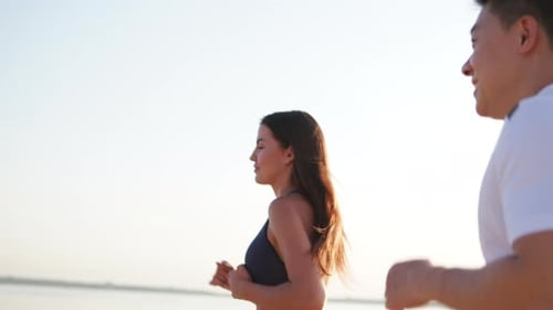 Young Adults Jogging on a Sunny Beach