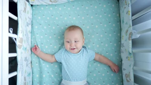 Baby Lying Awake and Smiling in Crib