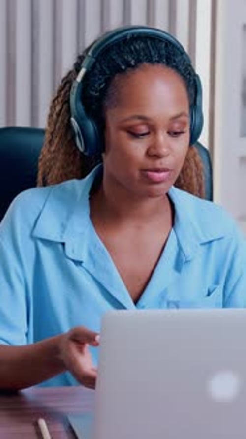 Woman Attending Online Meeting With Laptop and Headphones