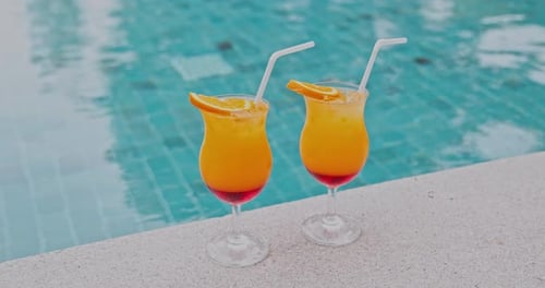 Tropische Cocktails stehen am Rand des Schwimmbades