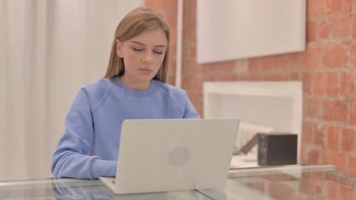 Young Woman Working on Laptop at Home