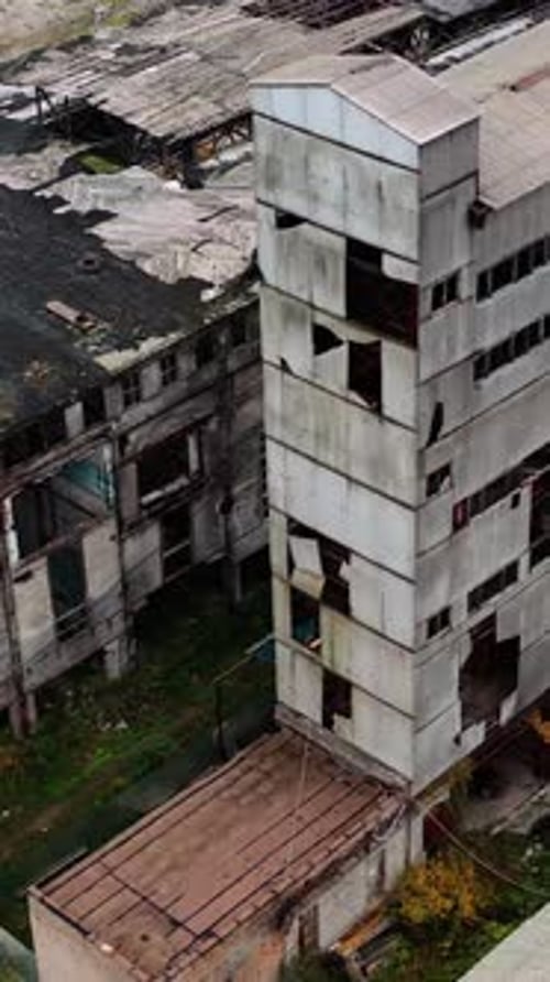 Ruined factory with damaged roof. Abandoned buildings on the field of military actions.