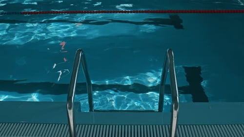 Leiter und plätscherndes blaues Wasser am flachen Ende des Schwimmbeckens vor der Eröffnung
