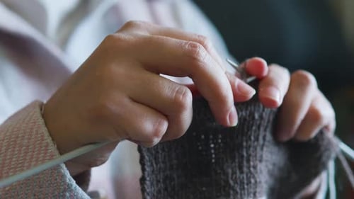 Close Up of Person Knitting with Brown Yarn