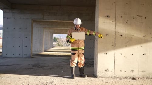 Un ingénieur ouvrier portant un casque blanc et un uniforme inspecte la qualité du béton par ultrasons
