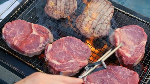 Raw Beef Steak is Being Roasted on the Grill Pan Outdoors