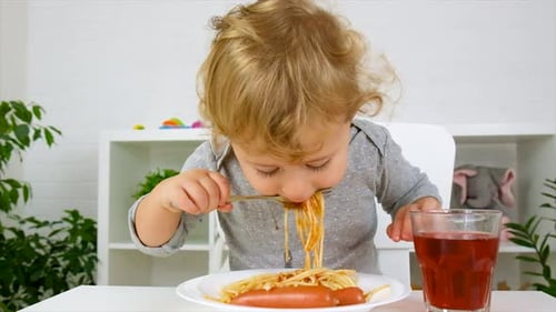 El niño come espaguetis para almorzar