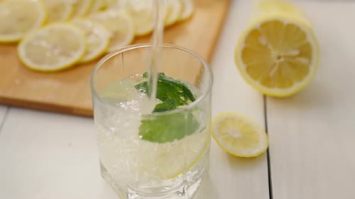 Lemonade Preparation with Lemon Slices and Fresh Mint