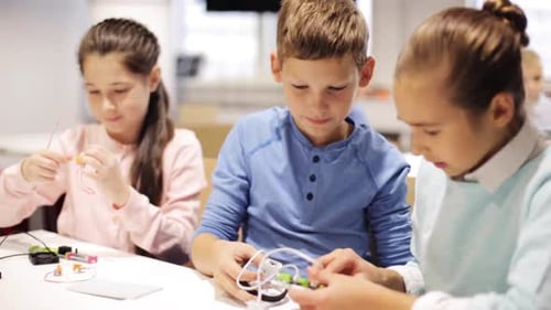 Smiling kids learn robotics and technology together at science school lesson