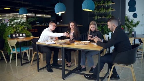 Coworkers Enjoying a Pizza Lunch at Restaurant