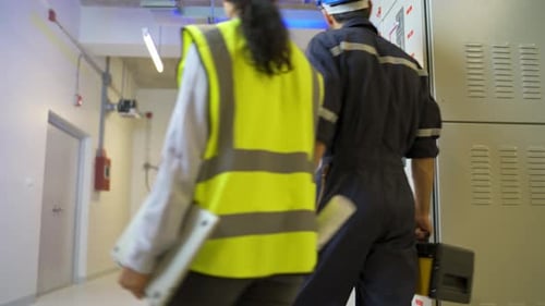 Professional engineer or technician workers hold toolsbox and discuss about electrical panel
