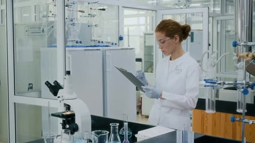 Female Scientist Taking Notes in Modern Lab
