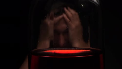 Man Behind Glass with Red Light Reflections