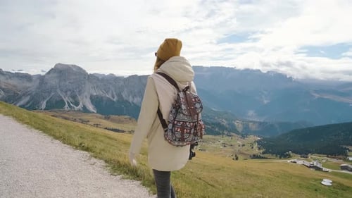 Beautiful Girl Traveler Walking in the National Park of Mountain Seceda in the Dolomites Incredible