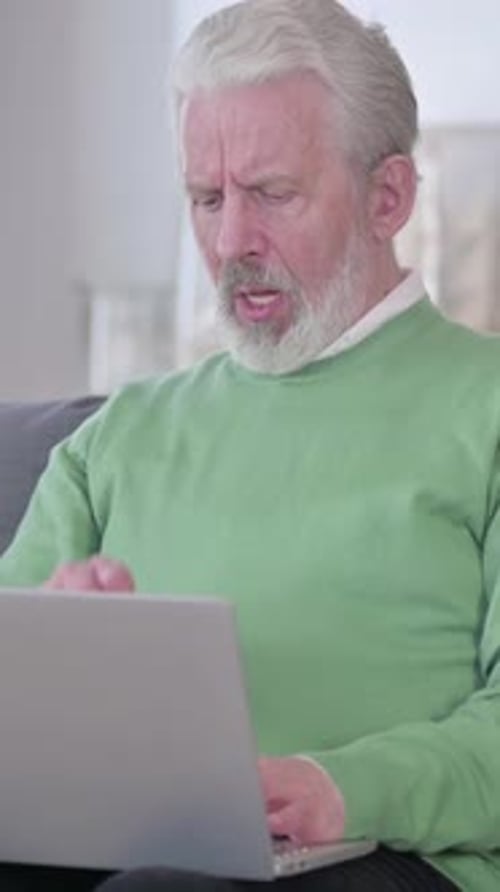 Senior Man Using Laptop While Sitting Indoors