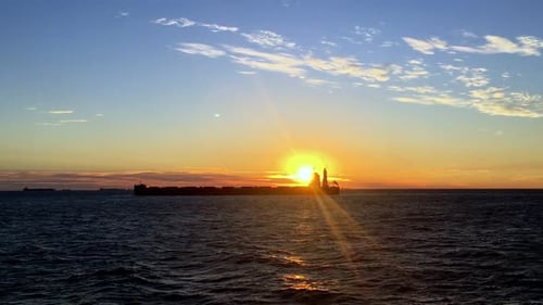A static shot of Cargo ship on sea in the rays of sun. A perfect sunrise view has been captured by c