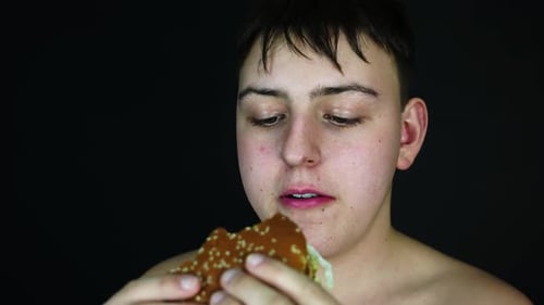 Young Overweight Man Eating Burger, Unhealthy Diet and Obesity Concept, Close Up