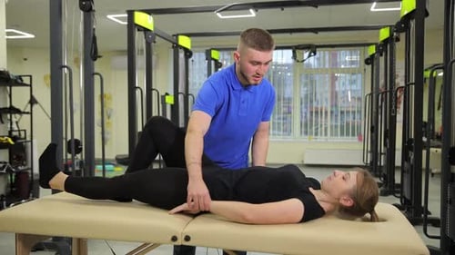 Man Stretching Woman on Table in Fitness Gym