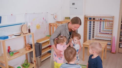 Woman Hugging Children in a Montessori Classroom