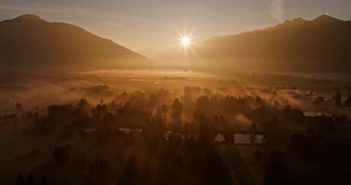 Foggy Forest And Mountains Bathed In The Sun's Golden Hues