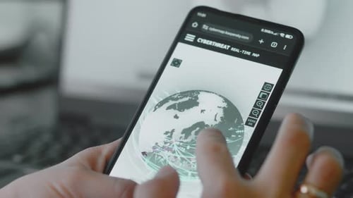Hand scrolling on Cyberattack map on a smartphone